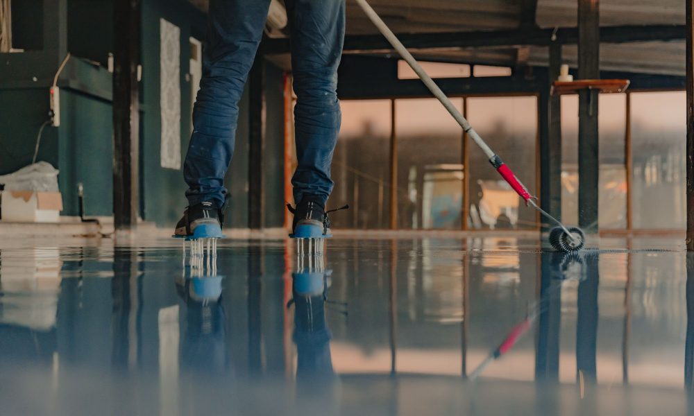worker-applies-gray-epoxy-resin-new-floor